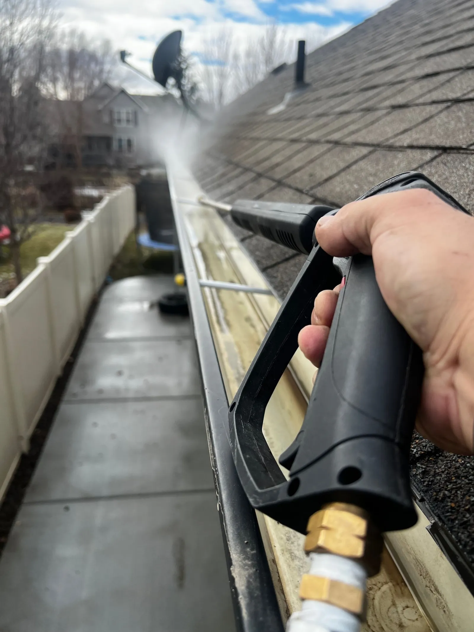 Close view of exterior gutter cleaning with a pressure nozzle