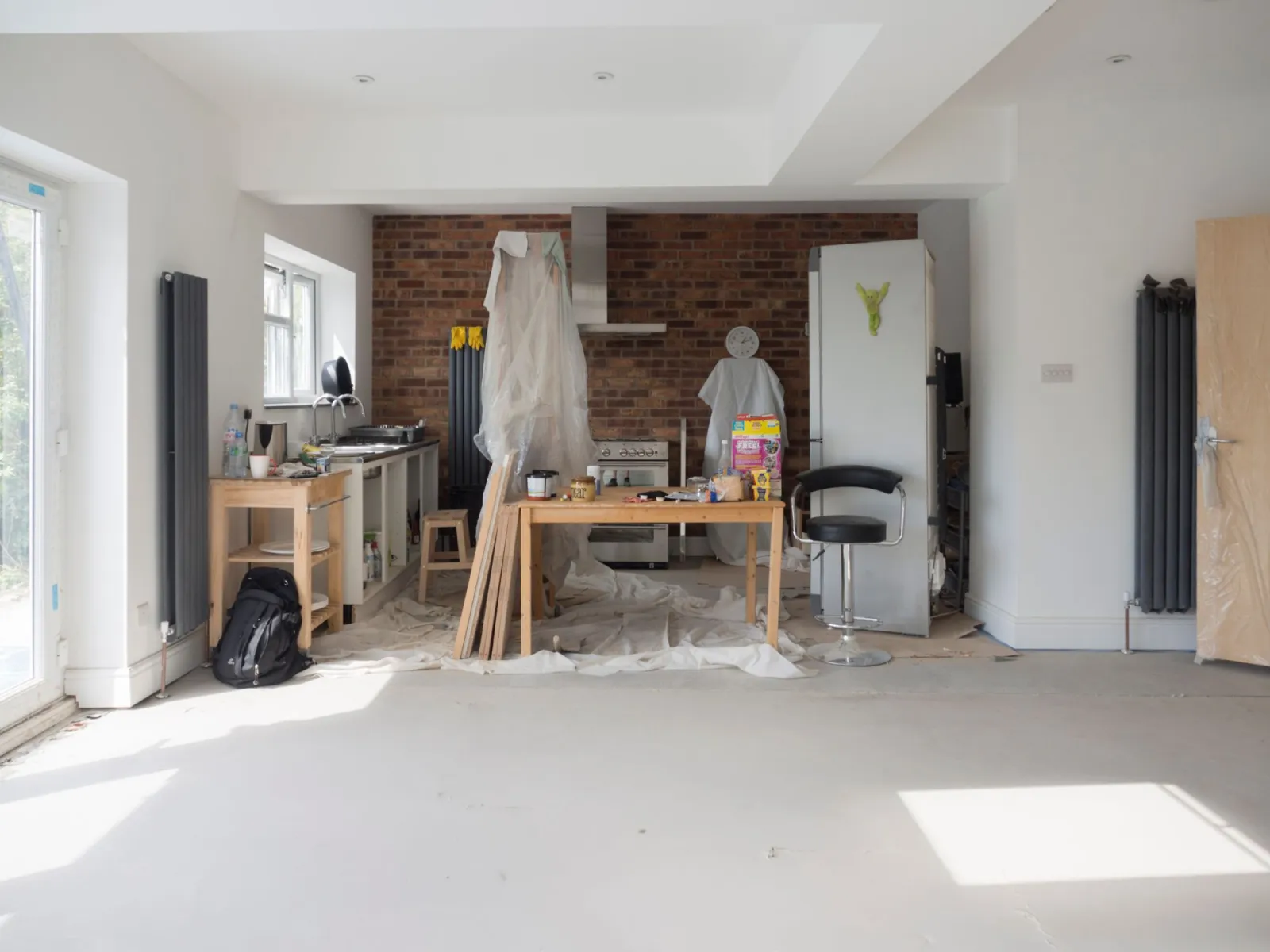 Bright kitchen renovation in progress with tools and protected surfaces