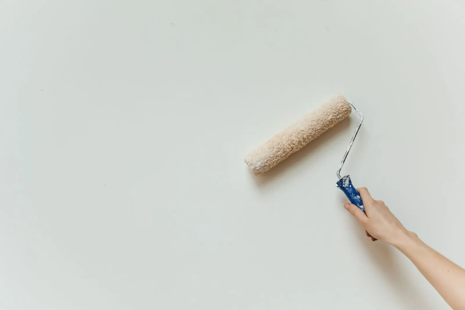 Paint roller applying a light finish across an interior wall