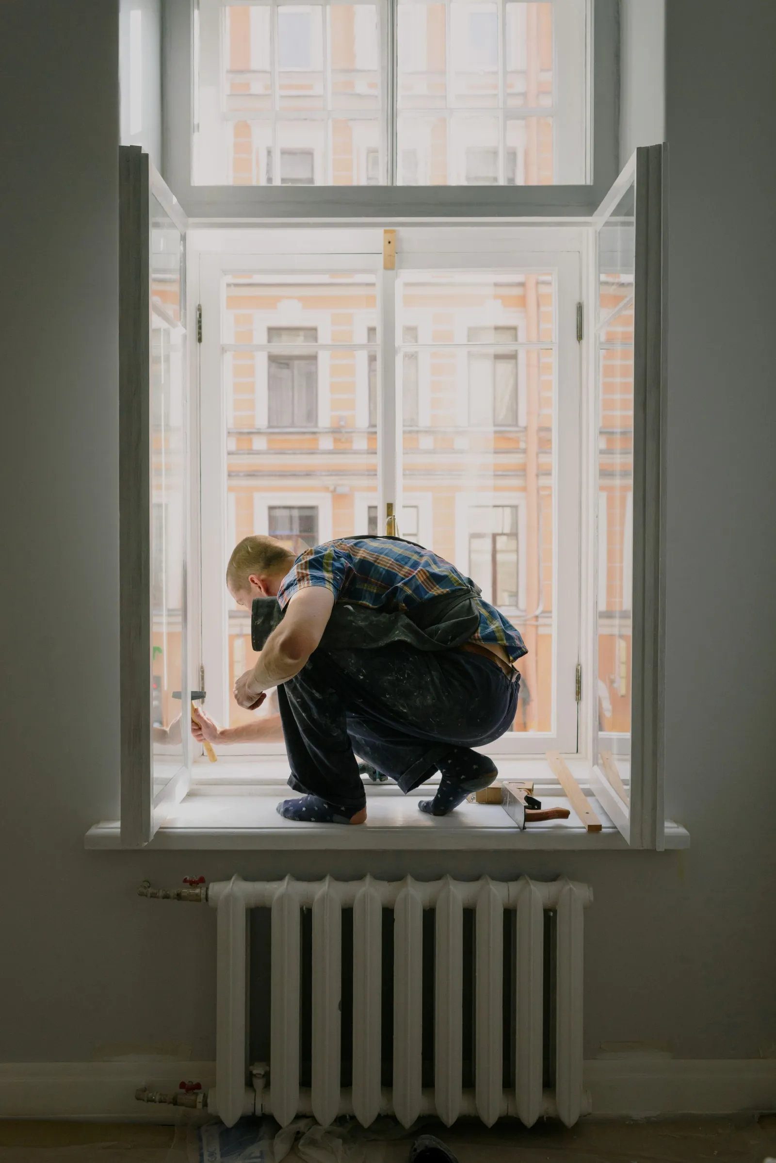 Tradesperson repairing an interior window frame