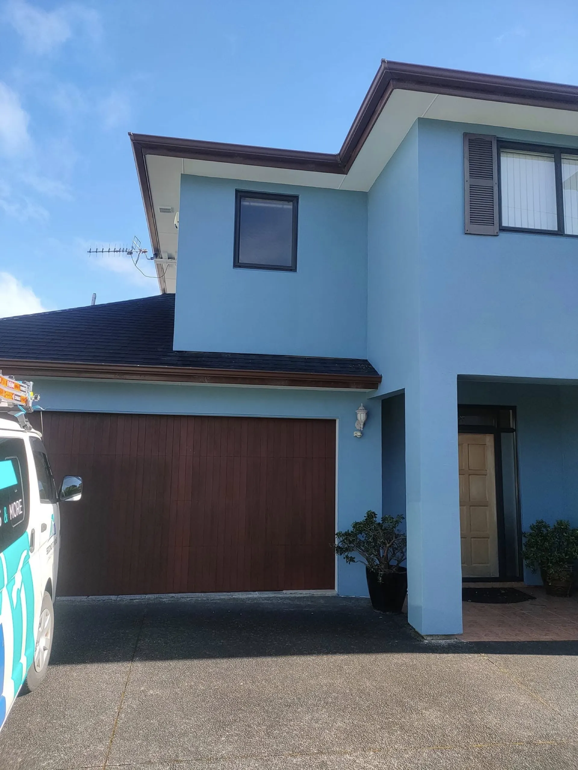 Finished two-storey Auckland home painted pale blue, with the Second to None van parked in the driveway