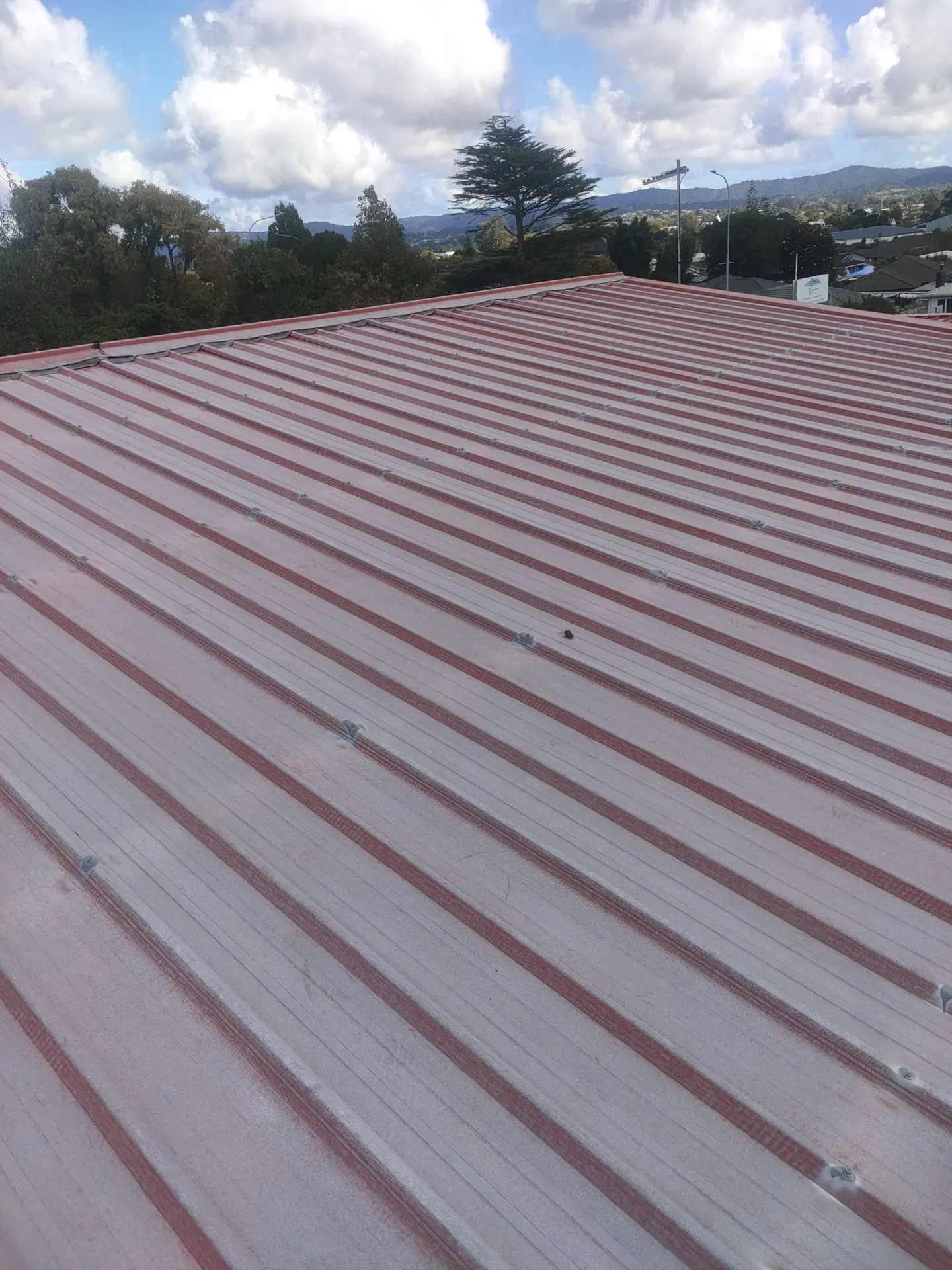 Long-run iron roof faded to a pale pink-red, before repainting