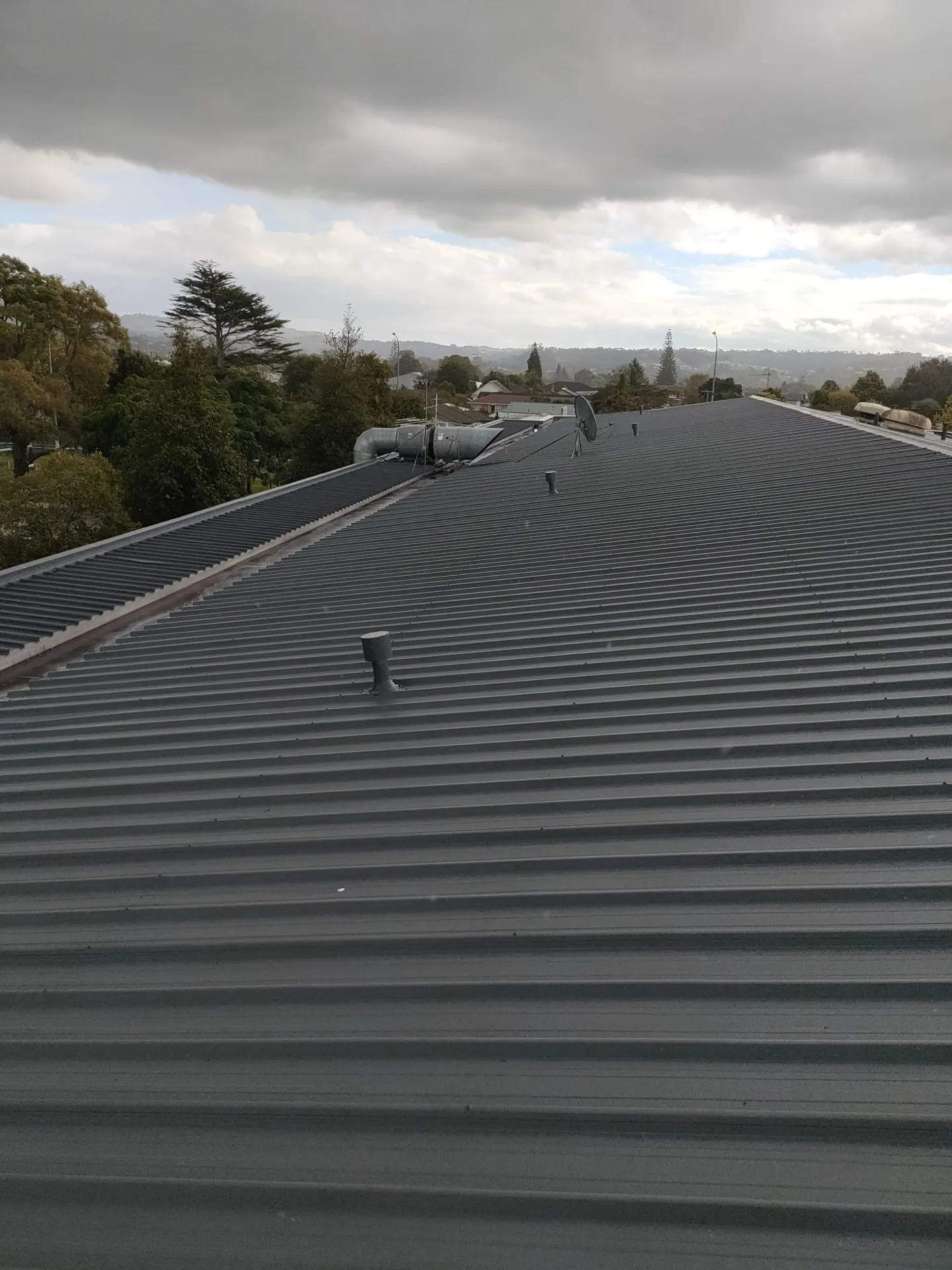 Long-run iron roof freshly repainted dark grey